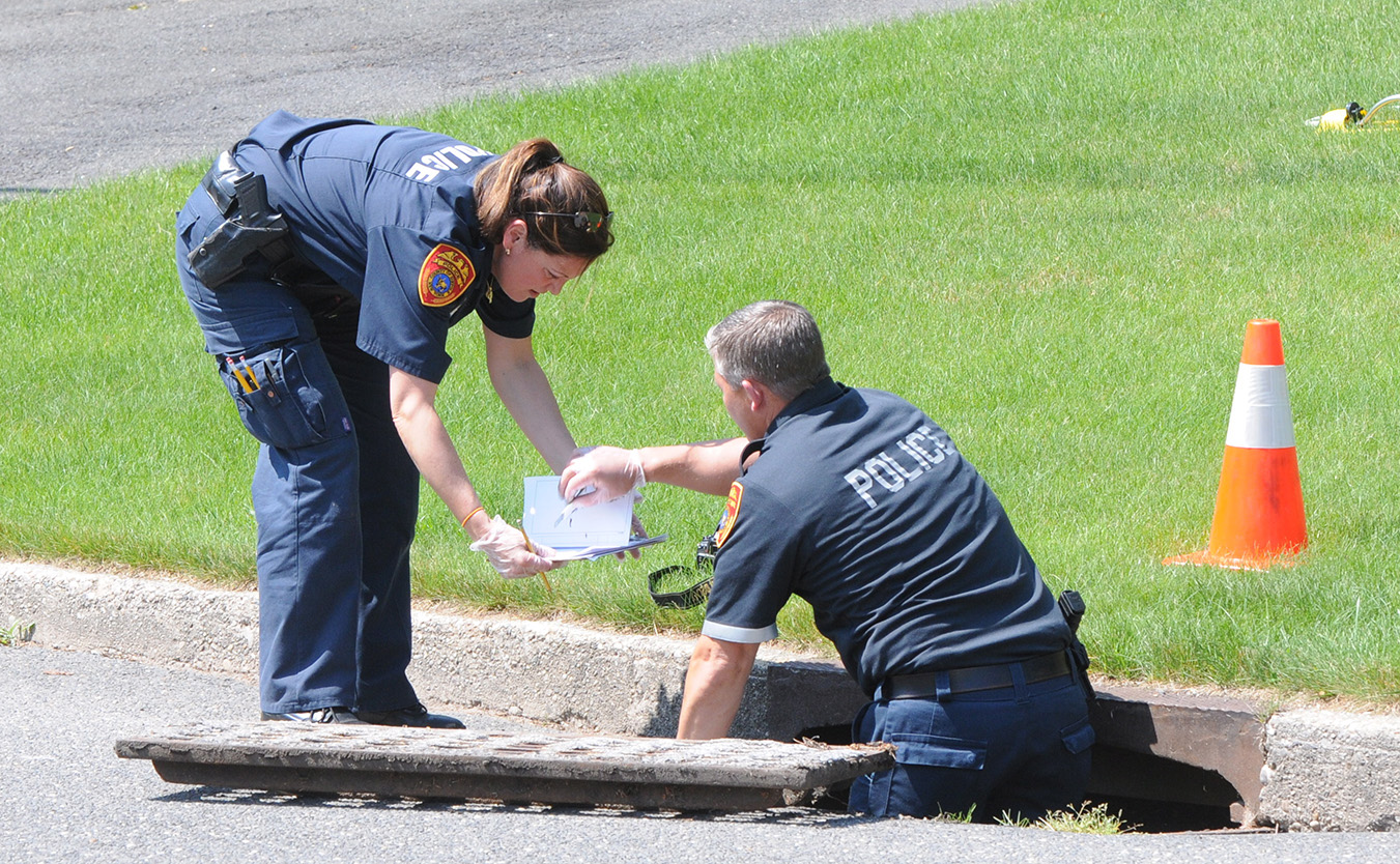 an officer placing evidence into a bag held by another officer